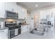 Modern kitchen with stainless steel appliances, gray countertops, white cabinets, and stylish fixtures at 5759 Bungalow Grove Ct, Palmetto, FL 34221