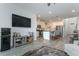 Open-concept living room showcasing a large television and a view of the modern kitchen and dining area at 5759 Bungalow Grove Ct, Palmetto, FL 34221