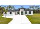 Stunning single-story home featuring a modern design with clean lines, black trim windows, and a bright white driveway at 5792 Nymph Ave, North Port, FL 34288