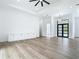 Open-concept living area featuring hardwood floors, recessed lighting, and a modern black trimmed glass front door at 5792 Nymph Ave, North Port, FL 34288