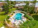 Aerial view showcasing a fenced-in community pool with lounge chairs and lush landscaping at 6348 7Th W Ave # 6348, Bradenton, FL 34209