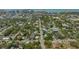 An aerial view captures a vibrant neighborhood with mature trees, and a stunning ocean view on the horizon at 640 N Osprey Ave, Sarasota, FL 34236