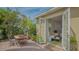 Outdoor dining area with French door entry to a living room and lush greenery at 640 N Osprey Ave, Sarasota, FL 34236