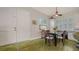Dining area featuring a dark table, neutral seating, white cabinetry, and natural light from shuttered windows at 640 N Osprey Ave, Sarasota, FL 34236