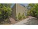 View of the exterior of the house with a brick and stone path, along with tropical plants and greenery at 640 N Osprey Ave, Sarasota, FL 34236