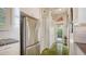 Galley kitchen boasts stainless steel fridge, white cabinets, and convenient access to the outdoors at 640 N Osprey Ave, Sarasota, FL 34236