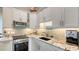 A modern kitchenette features granite countertops, white cabinets, and stainless steel appliances at 640 N Osprey Ave, Sarasota, FL 34236