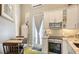 An efficient kitchenette boasts stainless steel appliances, white cabinets, and a cozy dining area at 640 N Osprey Ave, Sarasota, FL 34236