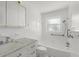 All-white bathroom featuring a shower and bathtub combo with grab bars and modern fixtures at 6715 Georgia Ave, Bradenton, FL 34207