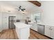 Bright kitchen with white cabinets, stainless steel appliances, an island, and a wooden beam accent at 6715 Georgia Ave, Bradenton, FL 34207