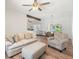 Living room features neutral colors, wood floors, ceiling fan, and is open to the dining and kitchen area at 6715 Georgia Ave, Bradenton, FL 34207