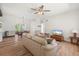 Bright living room features a ceiling fan, wood floors, and an open floor plan to dining and kitchen at 6715 Georgia Ave, Bradenton, FL 34207