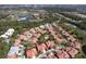 Scenic aerial view shows a neighborhood with red tile roofs near golf course and lake at 7340 Villa D Este Drive, Sarasota, FL 34238