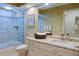 Bright bathroom vanity and walk in shower with granite countertop and decorative mirror at 7340 Villa D Este Drive, Sarasota, FL 34238