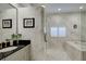 Bright bathroom with decorative wallpaper, granite countertop, and a soaking tub at 7340 Villa D Este Drive, Sarasota, FL 34238