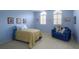Cozy blue bedroom features two windows and a comfortable loveseat at 7340 Villa D Este Drive, Sarasota, FL 34238