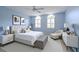 Soothing blue bedroom with white furniture, arched windows, and plenty of natural light at 7340 Villa D Este Drive, Sarasota, FL 34238