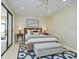 Bedroom with sliding glass doors, ceiling fan, and bench, allowing for plenty of natural light at 7340 Villa D Este Drive, Sarasota, FL 34238