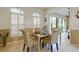 Dining area with a glass table, four chairs, shutters, and a view to the backyard at 7340 Villa D Este Drive, Sarasota, FL 34238