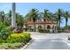 Community entrance with a fountain, lush landscaping, and a guardhouse, creating a welcoming and secure environment at 7340 Villa D Este Drive, Sarasota, FL 34238