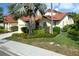 Charming home with red tile roof, lush landscaping, manicured lawn, and beautiful curb appeal at 7340 Villa D Este Drive, Sarasota, FL 34238