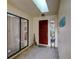 View of the foyer with brick-style tile flooring, skylight, and front door at 7340 Villa D Este Drive, Sarasota, FL 34238