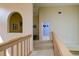 Upstairs hallway with wood railing and carpeting at 7340 Villa D Este Drive, Sarasota, FL 34238