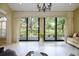 Bright living room features floor-to-ceiling windows with views of the backyard and lush landscaping at 7340 Villa D Este Drive, Sarasota, FL 34238