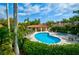 Community pool and spa with lounge chairs under a sunny sky, ideal for relaxation and socializing at 7340 Villa D Este Drive, Sarasota, FL 34238