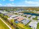 An aerial view showcasing the home's screened-in pool and landscaped yard, in a gated community with a lake at 8163 Redonda Loop, Lakewood Ranch, FL 34202