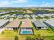 Aerial view of the back of several homes, highlighting a screened-in pool and a serene lake view at 8163 Redonda Loop, Lakewood Ranch, FL 34202