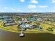 An aerial view of a community featuring a pool, clubhouse, tennis courts, lakes, and lush landscaping on a sunny day at 8163 Redonda Loop, Lakewood Ranch, FL 34202