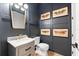 Modern bathroom with navy blue walls, decorative butterfly art, marble countertop, and gold faucet at 8163 Redonda Loop, Lakewood Ranch, FL 34202