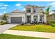 Charming two-story home featuring lovely landscaping, a paved driveway, and an attached two-car garage at 8163 Redonda Loop, Lakewood Ranch, FL 34202