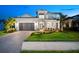 Inviting two-story home with a gray driveway, vibrant lawn, and well-maintained front garden at 8163 Redonda Loop, Lakewood Ranch, FL 34202