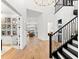 Spacious foyer with hardwood floors, a staircase, and an eye-catching light fixture, creating an inviting entrance at 8163 Redonda Loop, Lakewood Ranch, FL 34202