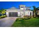 Stunning two-story home with a well-manicured lawn, a gray garage door, and beautiful front yard landscaping at 8163 Redonda Loop, Lakewood Ranch, FL 34202