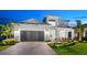 Charming two-story home with a well-manicured lawn, a gray garage door, and beautiful front yard landscaping at 8163 Redonda Loop, Lakewood Ranch, FL 34202