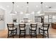 Modern kitchen showcases white cabinetry, marble island with bar stools, and stylish pendant lights at 8163 Redonda Loop, Lakewood Ranch, FL 34202