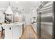 Bright, white kitchen with a large marble island, stainless steel refrigerator, and modern pendant lighting at 8163 Redonda Loop, Lakewood Ranch, FL 34202