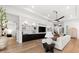 Open living room with built-in shelving, contemporary decor, wood floors, and access to other rooms at 8163 Redonda Loop, Lakewood Ranch, FL 34202
