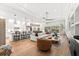 Open concept living room with wood floors, modern lighting, and white sofa open to the kitchen at 8163 Redonda Loop, Lakewood Ranch, FL 34202