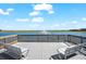 Scenic view from an outdoor deck with relaxing seating overlooking a serene lake featuring a water fountain at 8163 Redonda Loop, Lakewood Ranch, FL 34202
