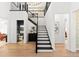 Staircase with black banister and black and white stairs, with a view to the hallway, and bathroom at 8163 Redonda Loop, Lakewood Ranch, FL 34202