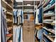 A tidy walk-in closet features multiple hanging rods, shelving and drawer units at 8163 Redonda Loop, Lakewood Ranch, FL 34202