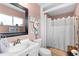 Clean and functional bathroom with a white sink, toilet, framed mirror and shower at 8718 Gaillard Ave, North Port, FL 34287