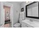 Modern bathroom featuring a white vanity, framed mirror, toilet, and walk-in shower with tiled floors at 8718 Gaillard Ave, North Port, FL 34287
