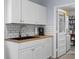 Practical laundry room with white cabinets, sink, and washer/dryer hookups at 8718 Gaillard Ave, North Port, FL 34287