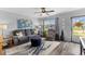Cozy living room featuring a comfortable gray sofa, a ceiling fan, and ample natural light at 8718 Gaillard Ave, North Port, FL 34287