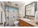 Bathroom with granite vanity and beach-themed shower curtain at 1650 1St W Ave # 503B, Bradenton, FL 34205